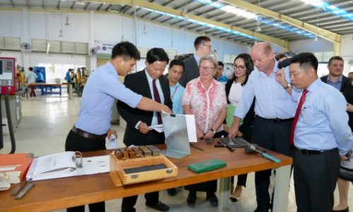 Mr Huy, teaching staff at LILAMA 2, shows Ms Möhring (BMZ) various documents related to the use of machinery at the Construction Mechanics / Metal Cutting-CNC workshop at LILAMA 2.