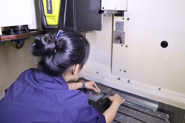 A participant fastened her workpiece into the CNC milling vice.