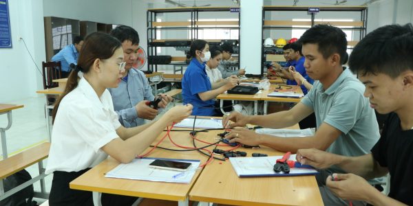 Participants practice stripping wires and crimping the MC4 connectors.