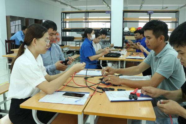 Participants practice stripping wires and crimping the MC4 connectors.