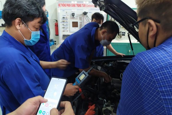 Chuyên gia cùng các giáo viên đang thao tác sử dụng máy nội soi động cơ