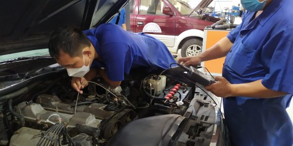 Các giáo viên đang thực hành nội soi động cơ ô tô.