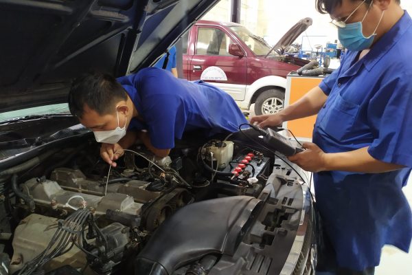 Các giáo viên đang thực hành nội soi động cơ ô tô.