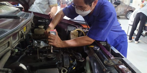 Giáo viên đang thực hành kiểm tra áp suất động cơ.