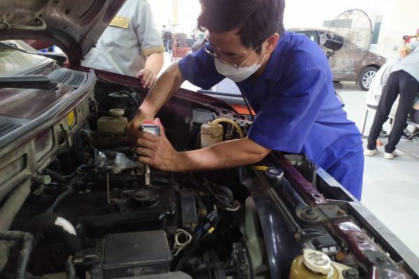Giáo viên đang thực hành kiểm tra áp suất động cơ.