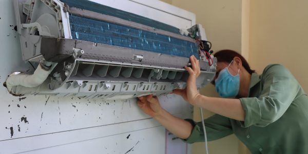 The teacher was installing wall-hanging air-conditioner